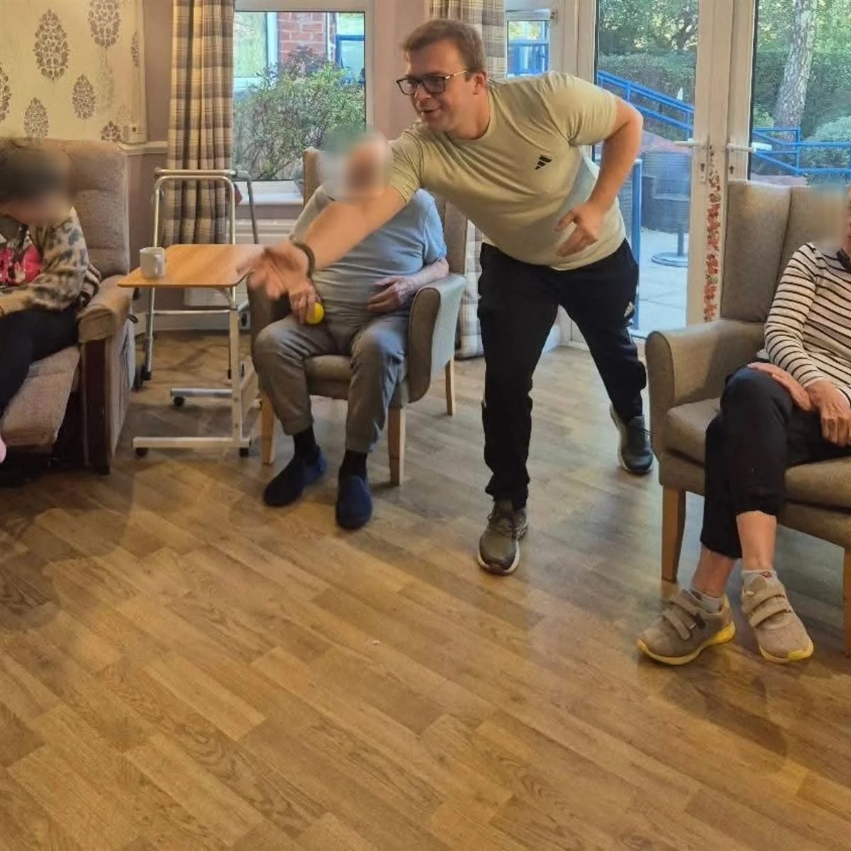 Andrew Hill leading a seated ball game with care home residents